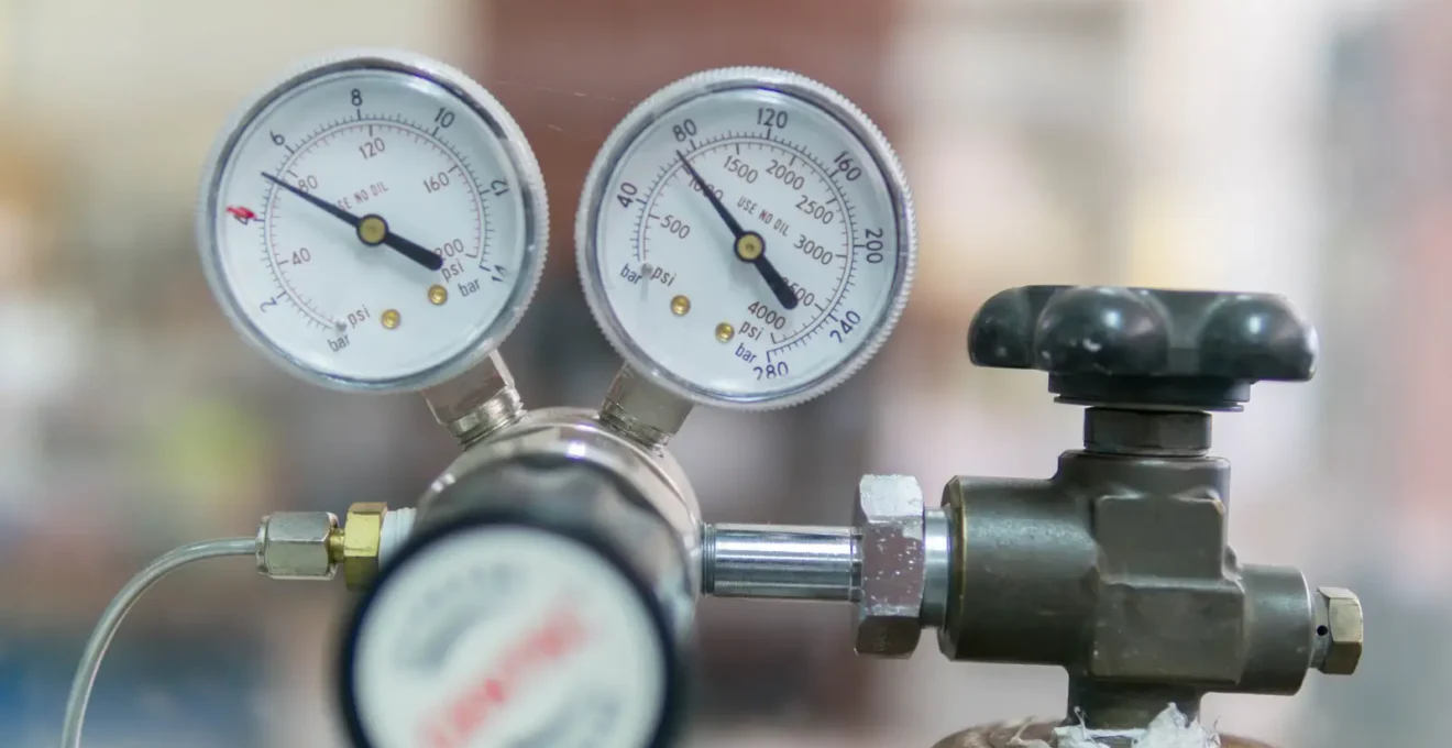 Technicien effectuant un relevé du niveau de gaz sur une citerne de propane avec équipement de mesure